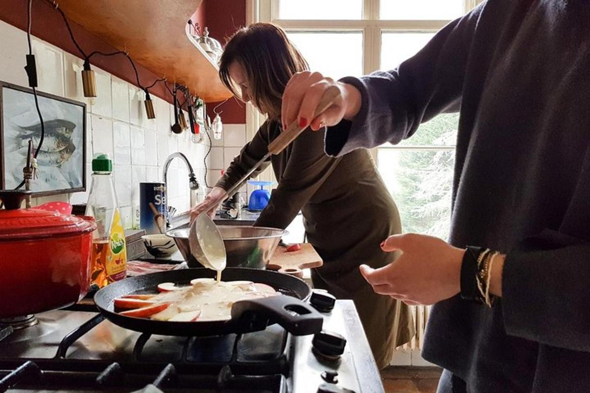 Maður og kona elda mat á pönnu á eldavél
