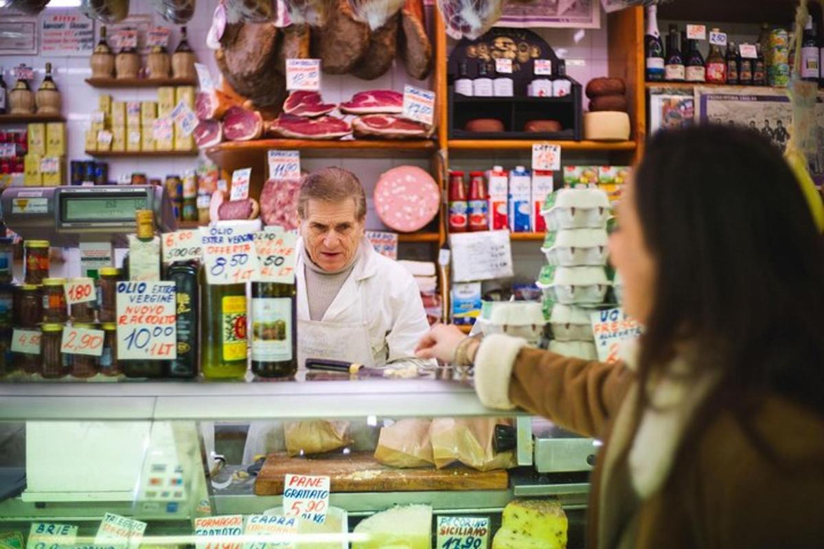 Una mujer comprando comida en una tienda de comestibles con un cajero.