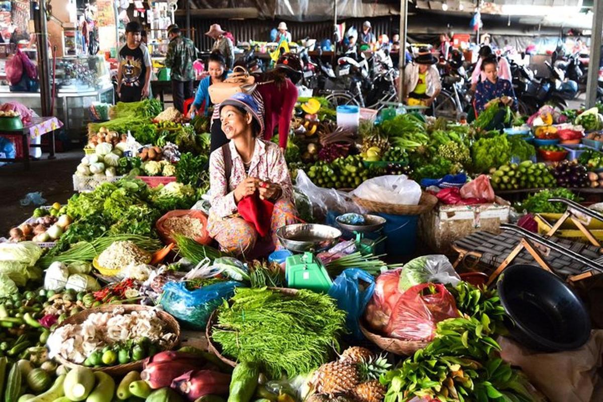 una donna seduta su una pila di verdure in un mercato
