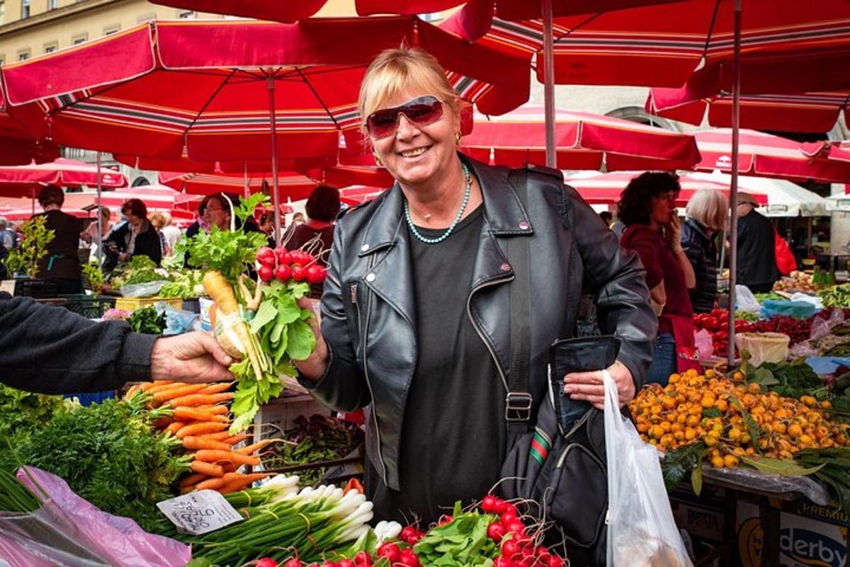 a woman standing in front of a market with vegetables