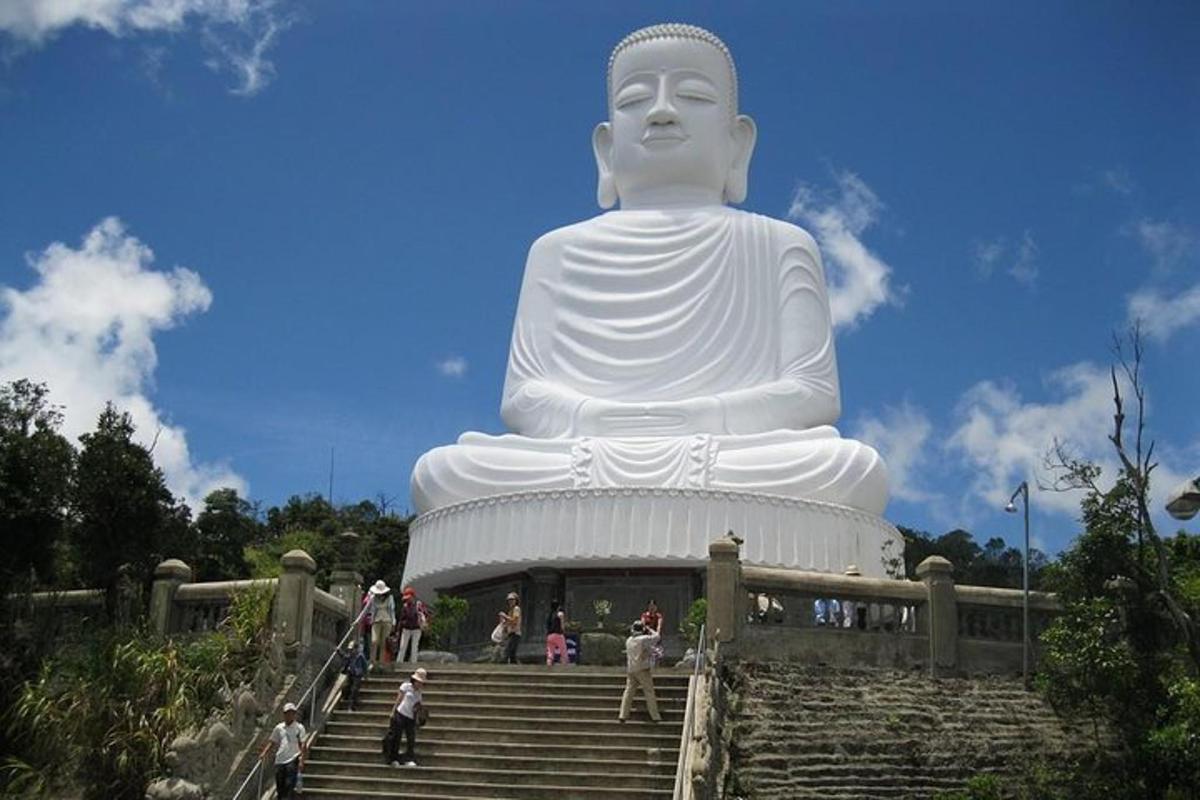 một bức tượng phật lớn ngồi trên đỉnh cầu thang