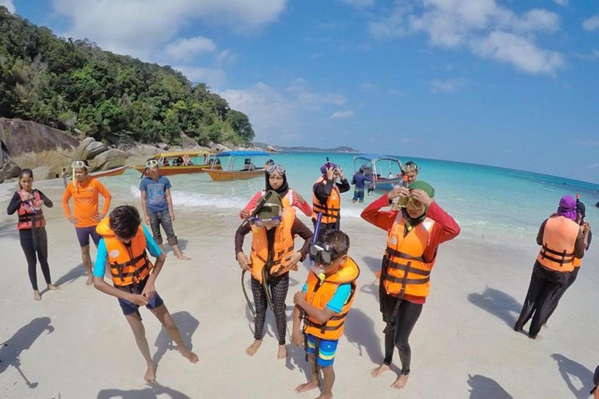 a group of people in life jackets on the beach