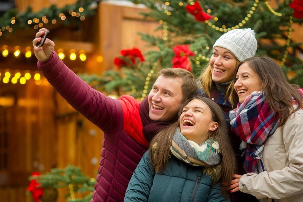 eine Gruppe von Menschen posiert für ein Foto vor einem Weihnachtsbaum