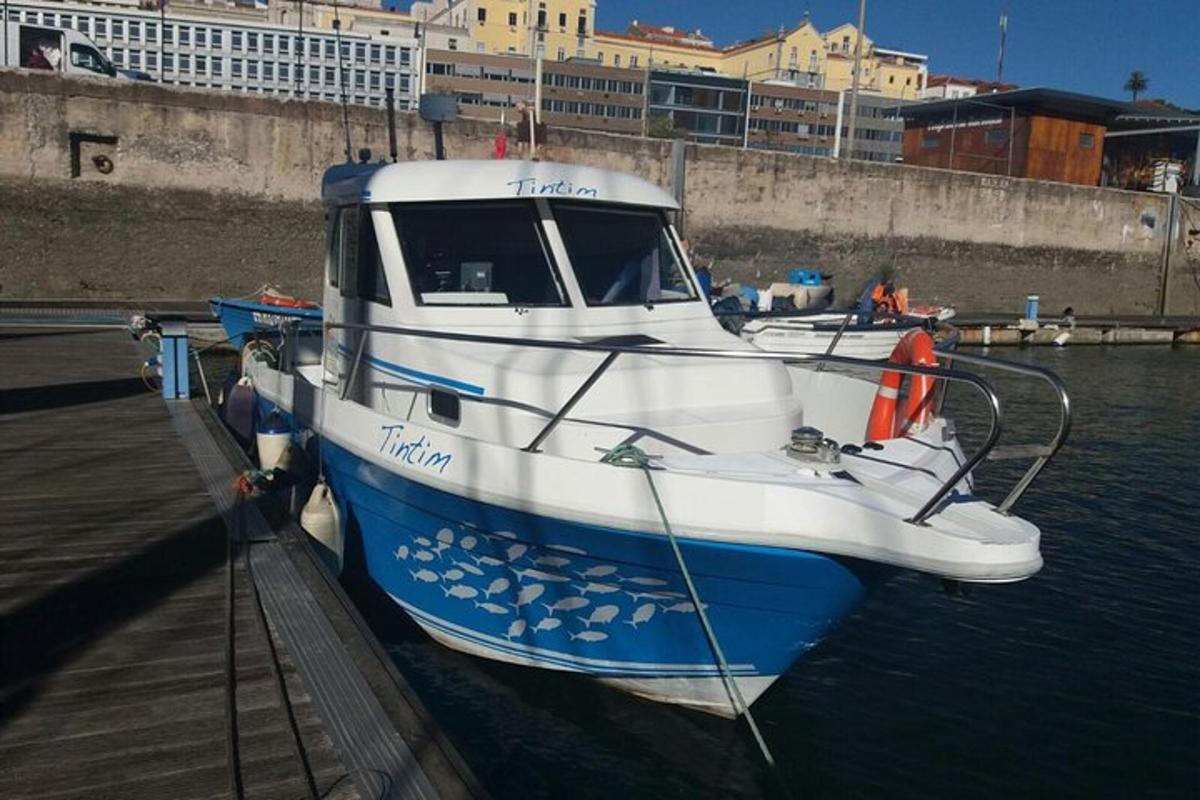en blå og hvit båt fortøyd ved en brygge
