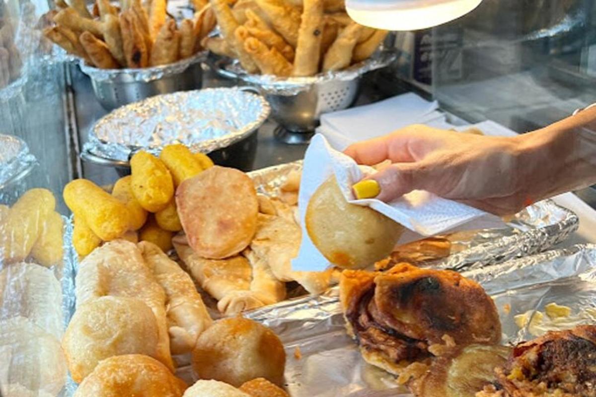 a person taking a piece of food from a table of food