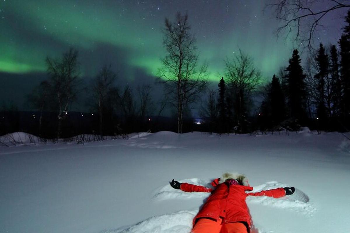 egy személy fekszik a hóban egy snowboarddal