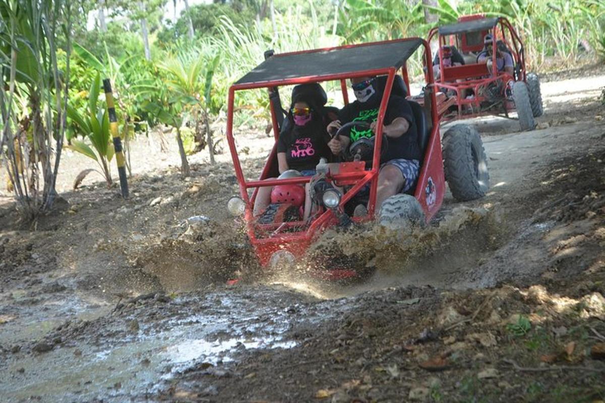 a group of people riding in a toy car on a dirt road