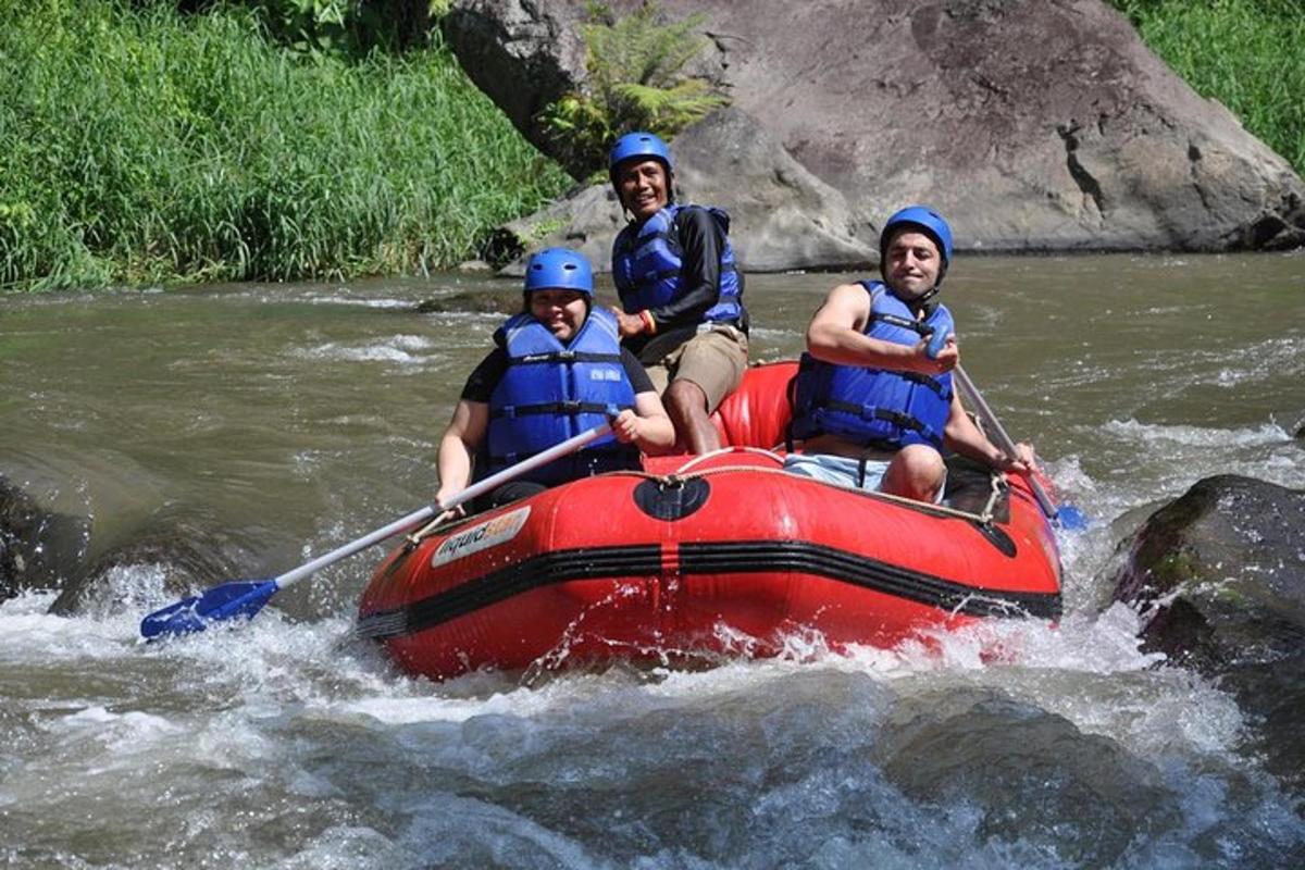 three people in a red raft on a river