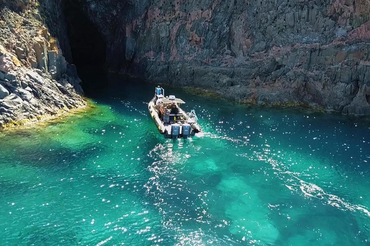 a boat in the water next to a cave