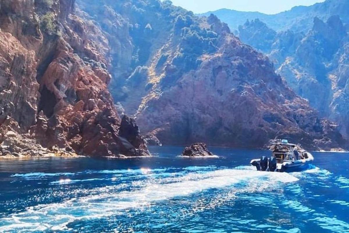 a boat in the water next to a mountain