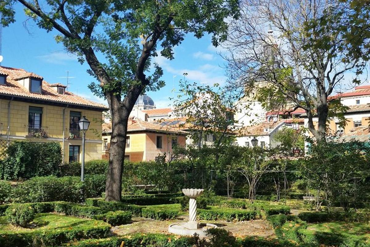 ένας κήπος μπροστά από ένα σπίτι με δέντρα και θάμνους
