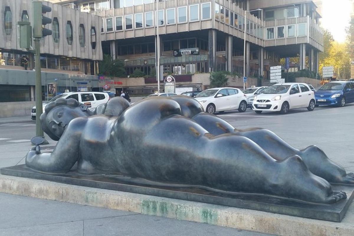 ένα χάλκινο άγαλμα μιας γυναίκας ξαπλωμένης στο έδαφος