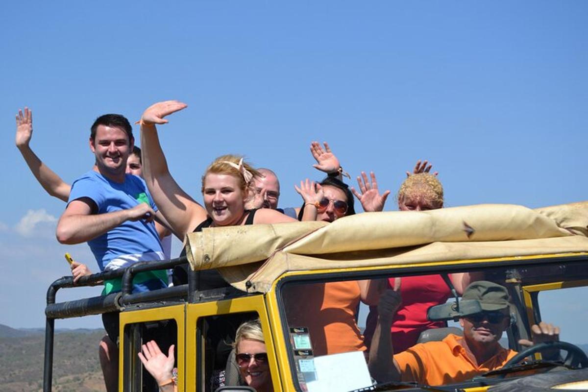 skupina lidí jedoucí na střeše autobusu