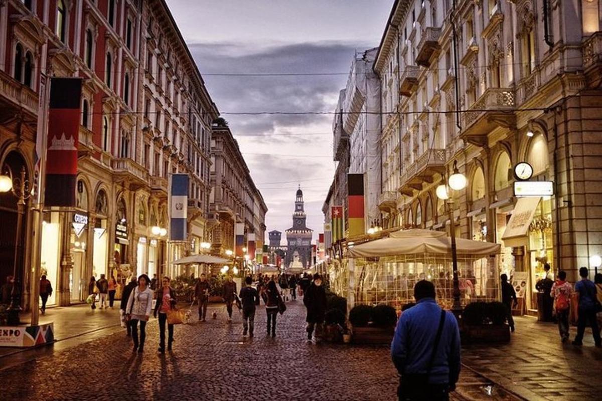 skupina ljudi, ki hodijo po ulici z zgradbami