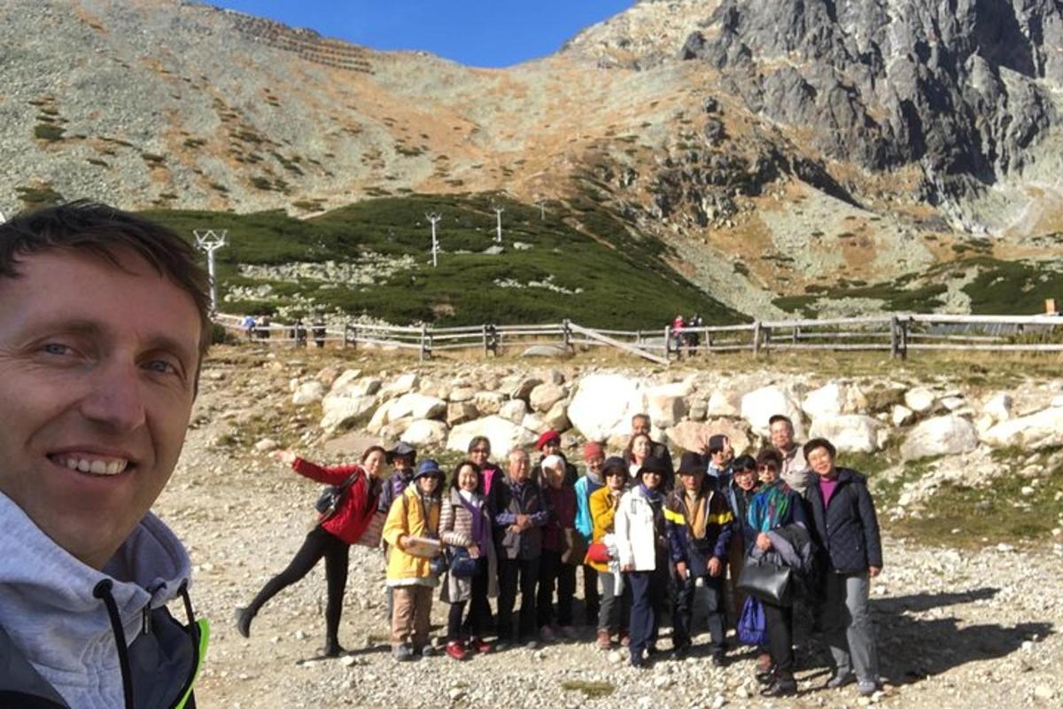 a group of people standing in front of a mountain