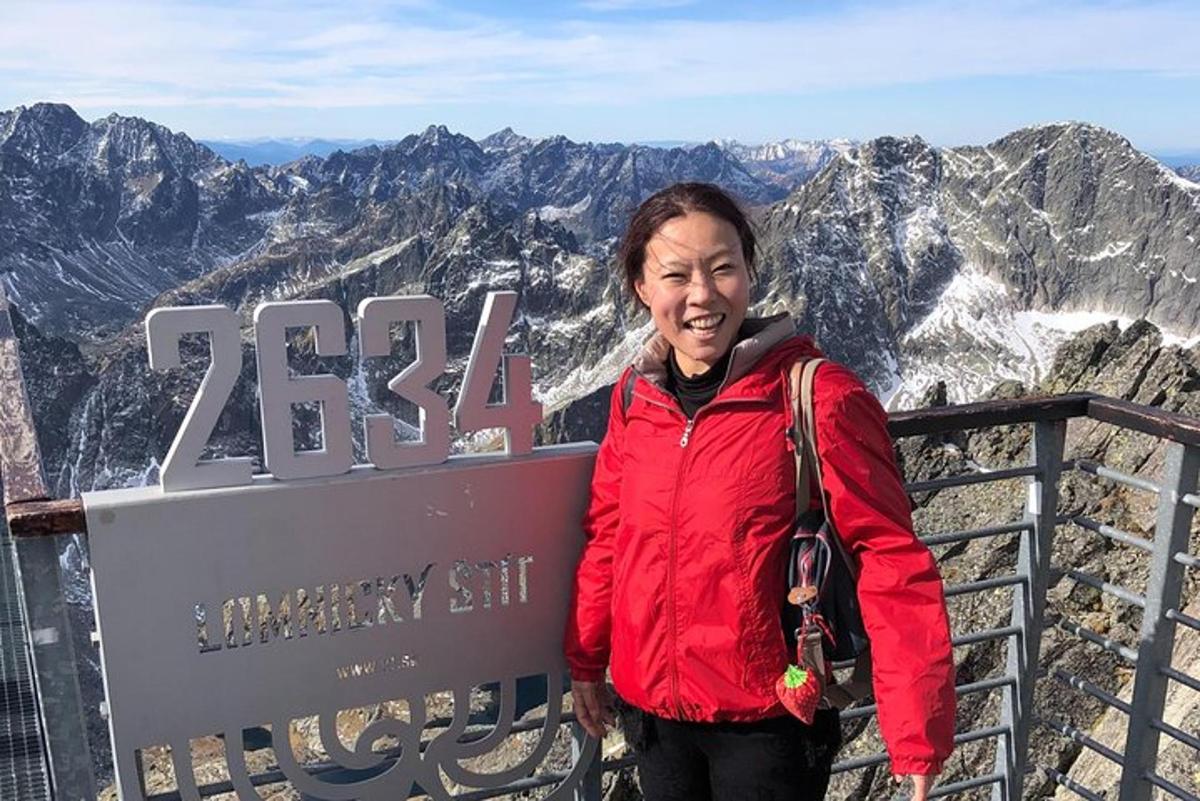 a woman standing on the top of a mountain