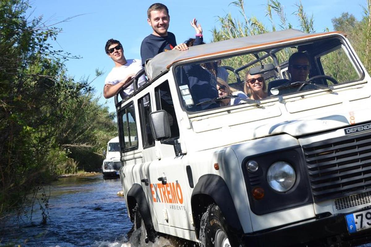 a group of people in a jeep driving through a river