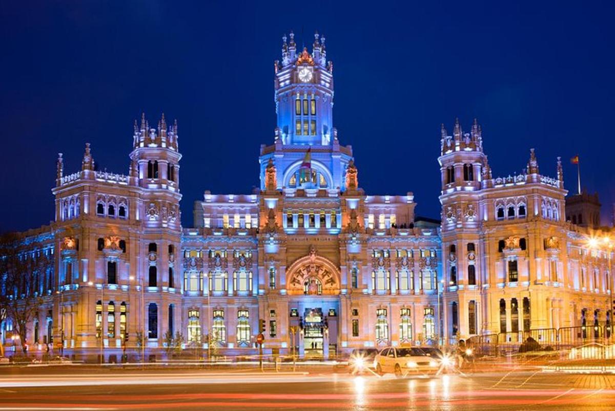 Un gran edificio con una torre de reloj por la noche.