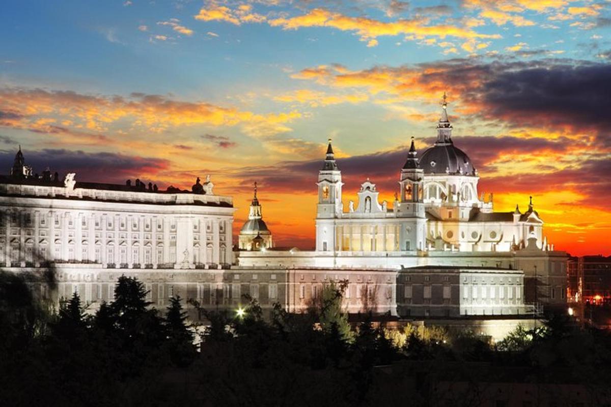 Un gran edificio blanco con una puesta de sol al fondo.