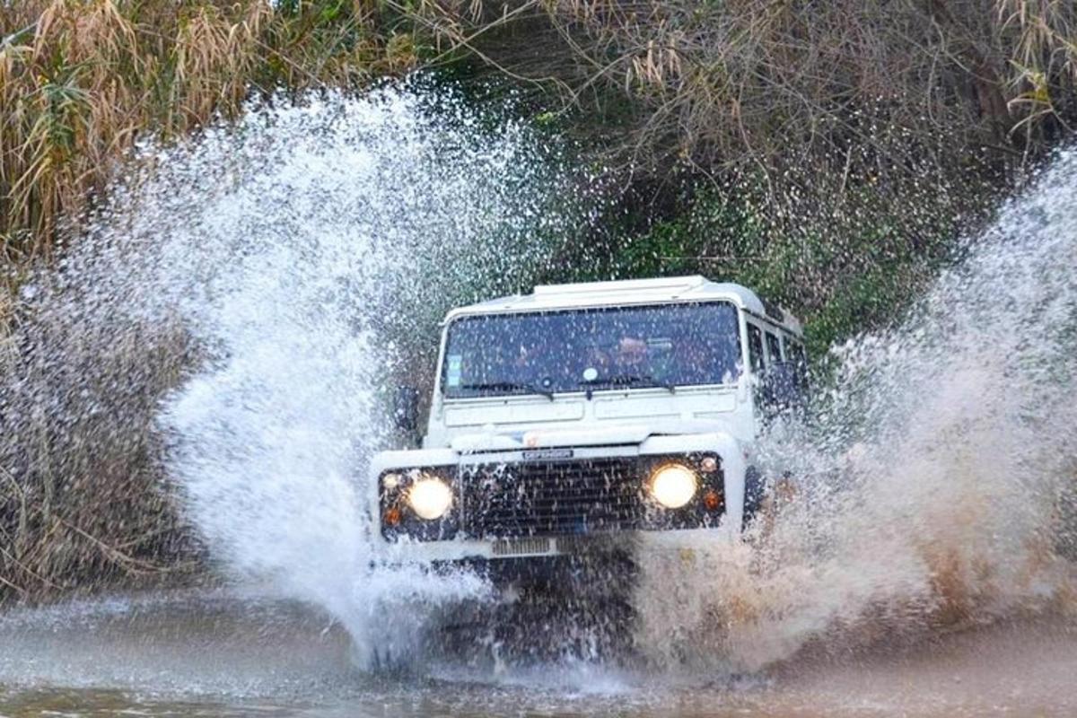 a jeep driving through the water on a road