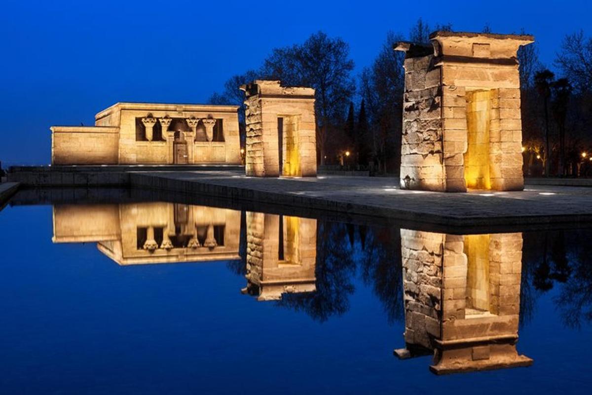 Un edificio con su reflejo en el agua por la noche.