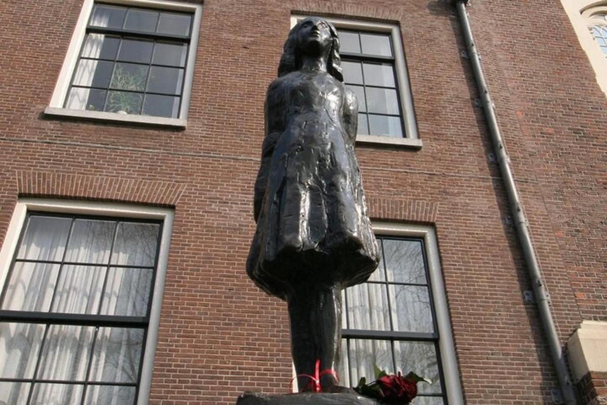 eine Statue einer Frau vor einem Backsteingebäude
