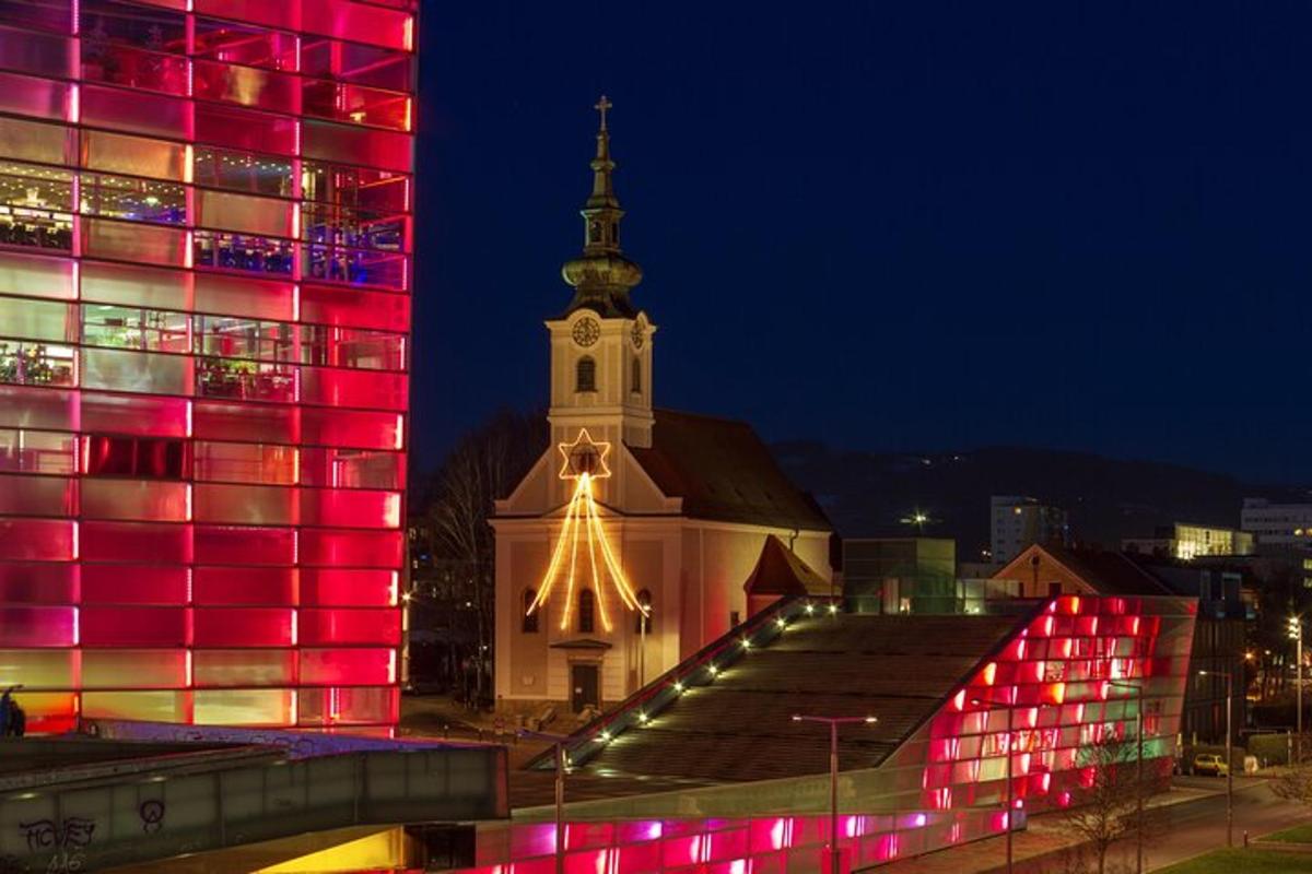 um grande edifício com uma igreja com um campanário à noite