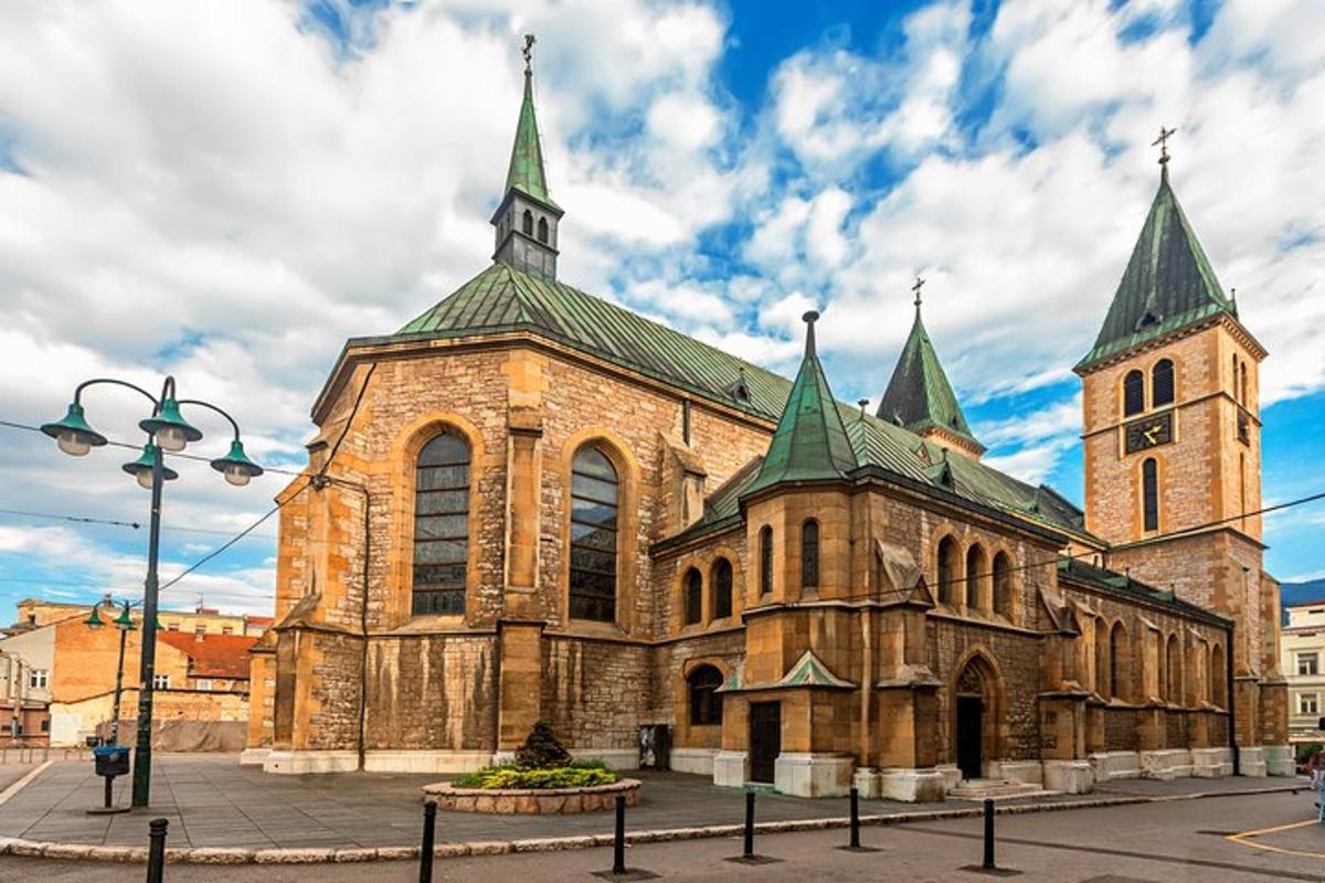 una grande chiesa in pietra con torri verdi su una strada