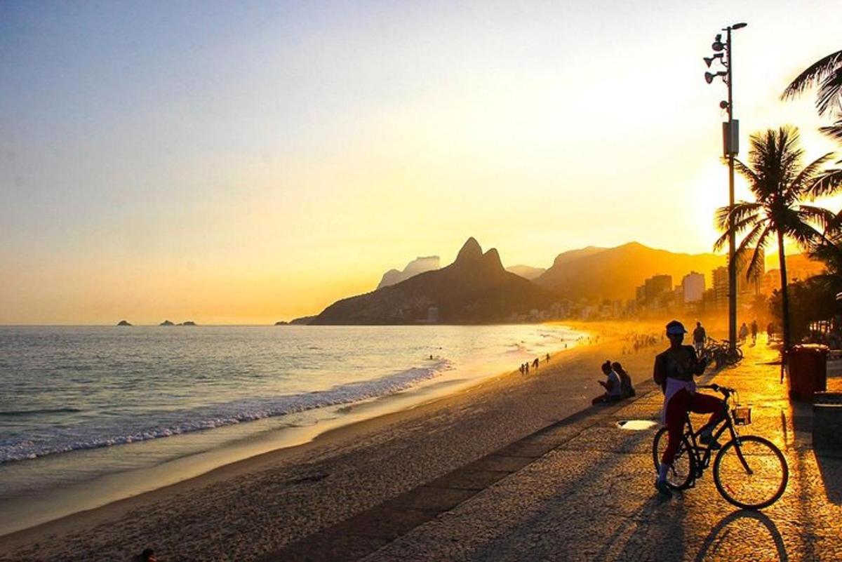 una persona in bicicletta sulla spiaggia al tramonto