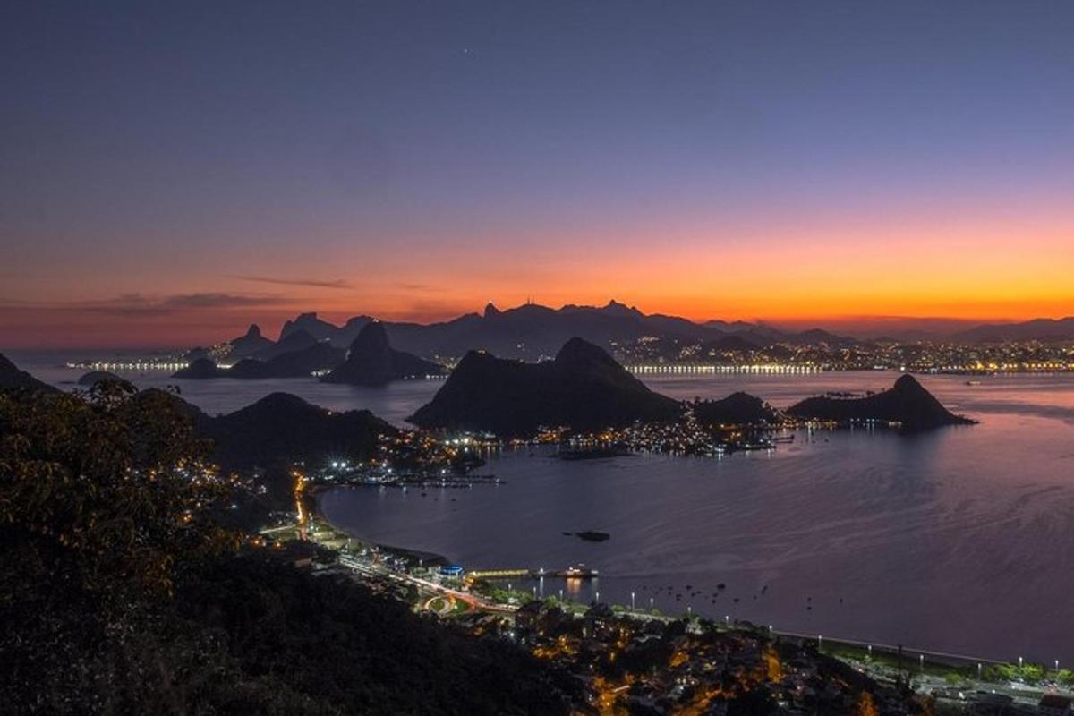 una vista di una città con montagne e oceano di notte
