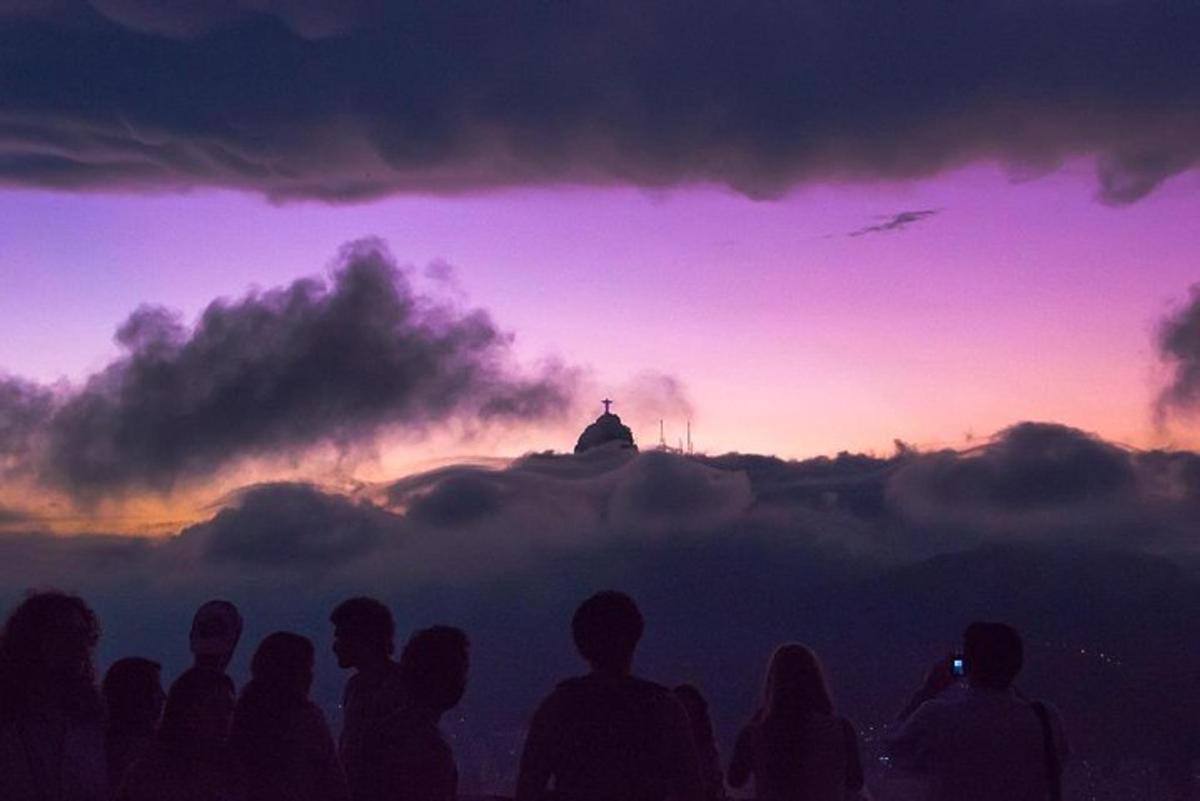 un gruppo di persone in piedi di fronte a un tramonto