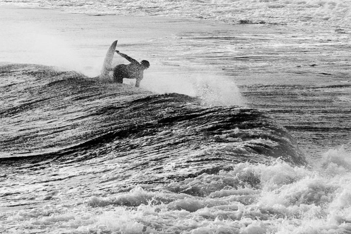un uomo che cavalca un'onda su una tavola da surf nell'oceano