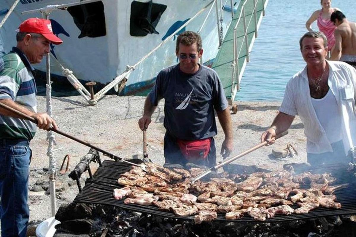 група мушкараца који пеку месо на роштиљу