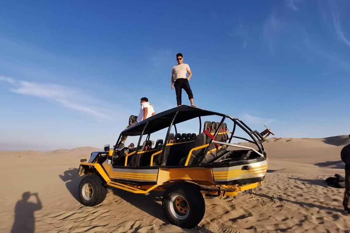 un uomo in piedi in cima a una jeep nel deserto