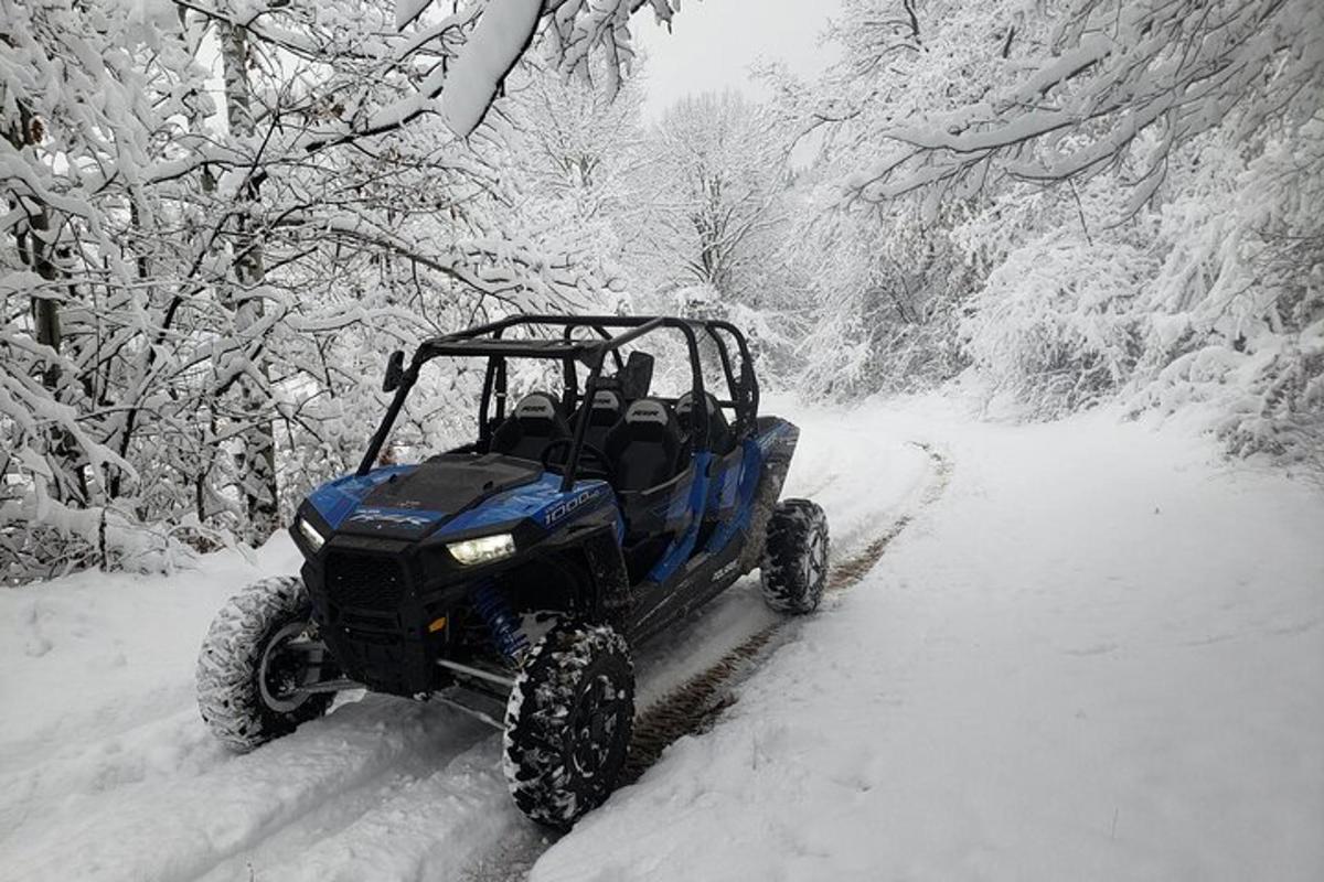 a blue atv driving down a snow covered road