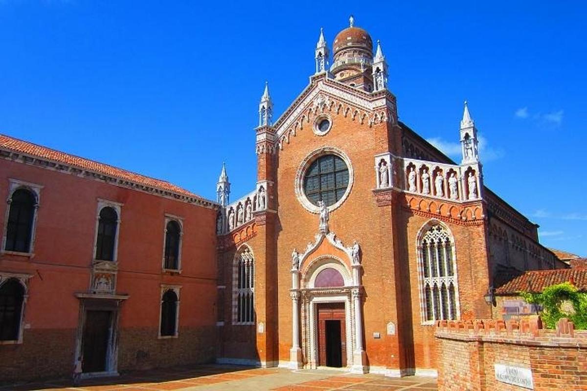 un grand bâtiment en briques rouges avec une tour d'horloge