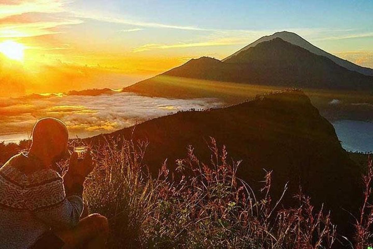 a woman taking a picture of the sunset