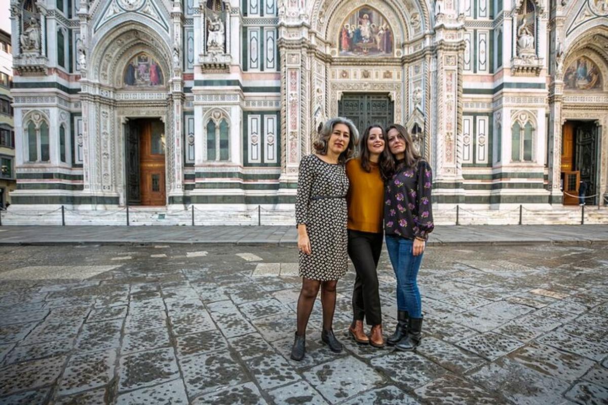 trois femmes debout devant un bâtiment