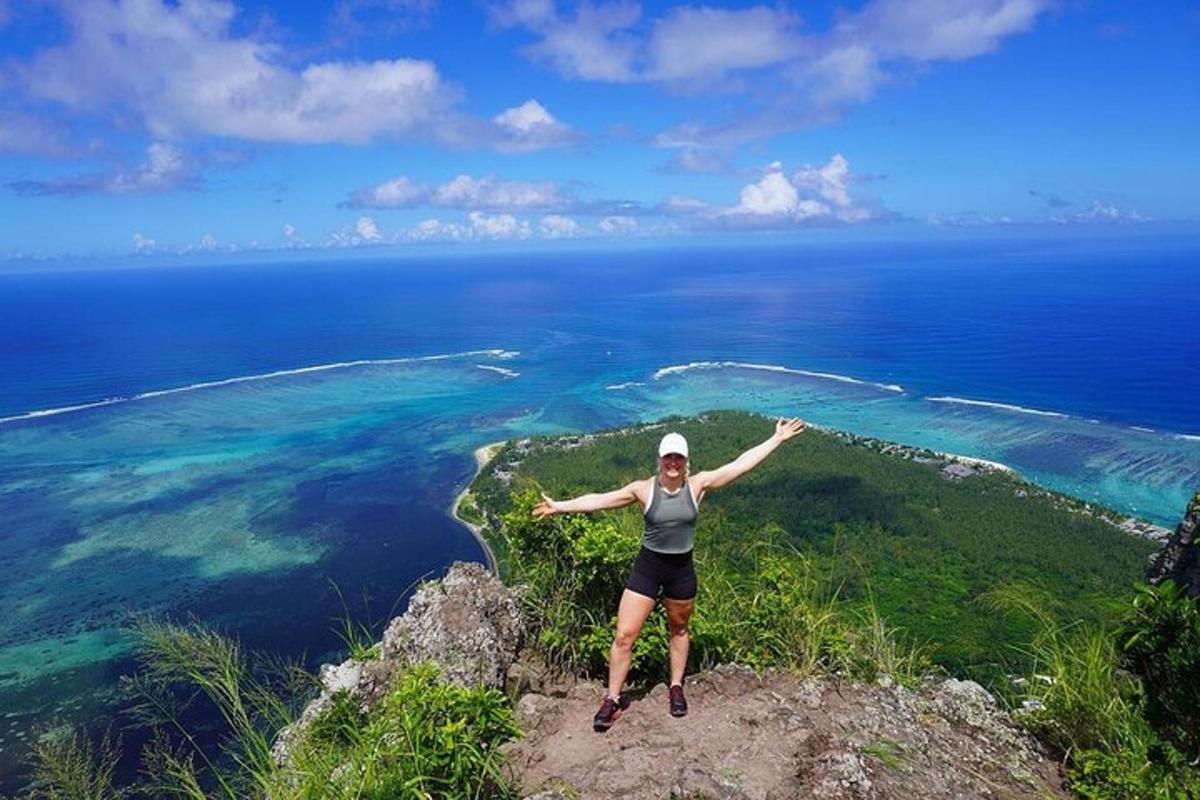 una donna in piedi in cima a una scogliera che domina l'oceano