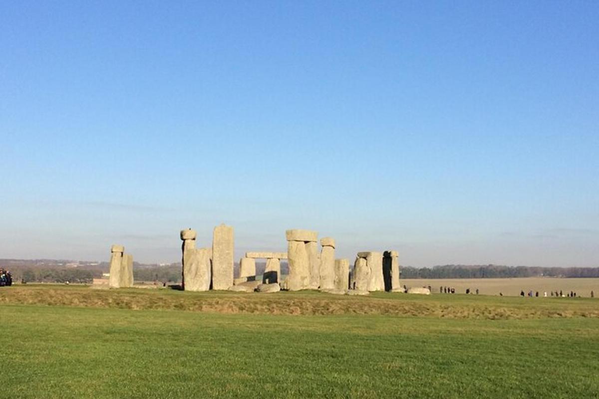 monumen stonehenge di padang dengan rumput hijau