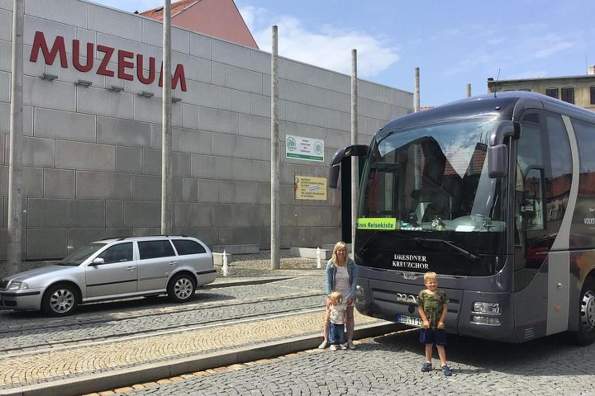 una dona i un nen drets al costat d'un autobús