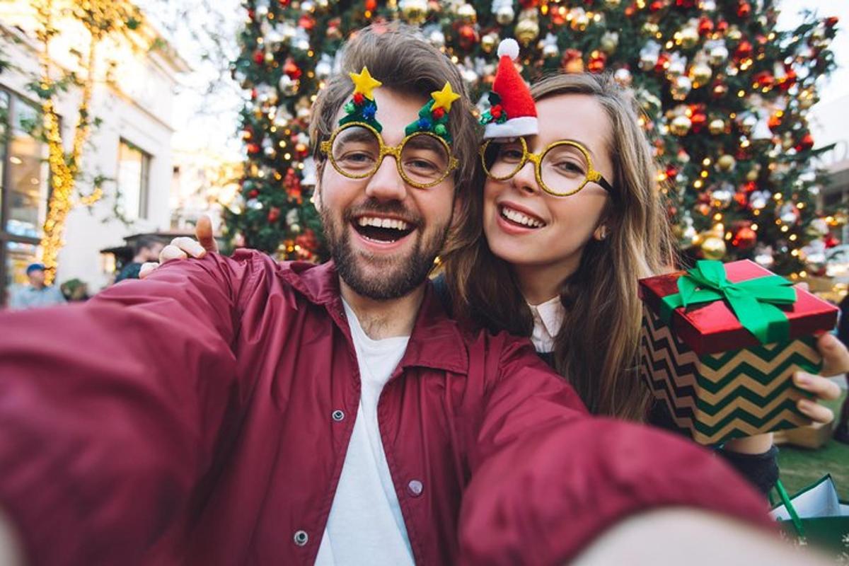 seorang lelaki dan seorang wanita berdiri di sebelah pokok krismas