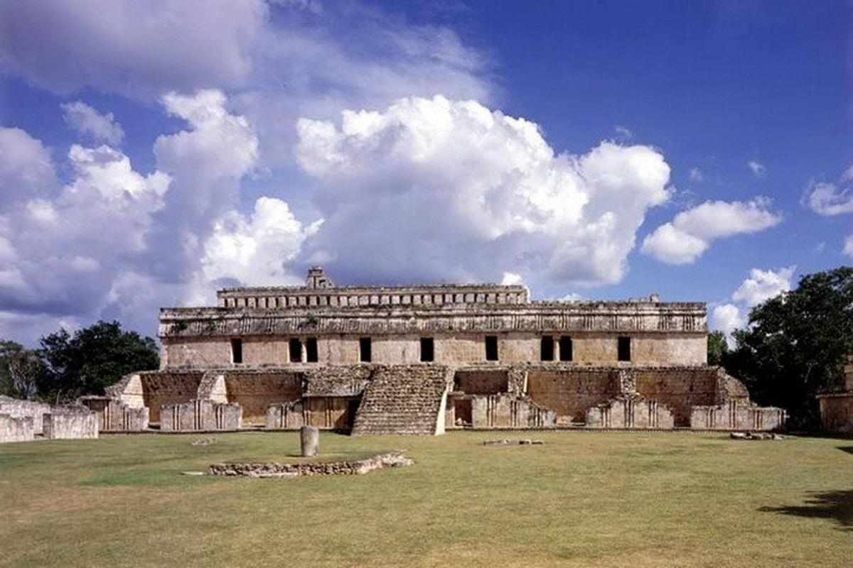 um grande edifício com um campo de grama na frente