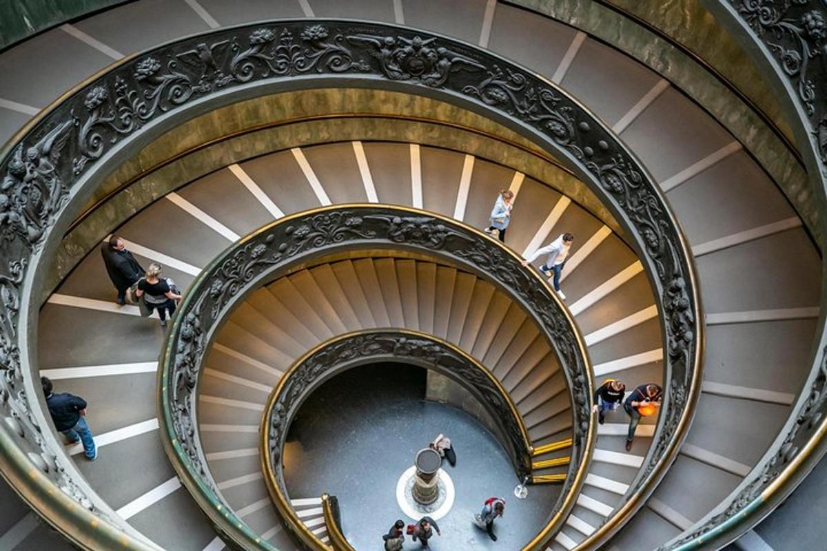 a spiral staircase in a building with people walking down it