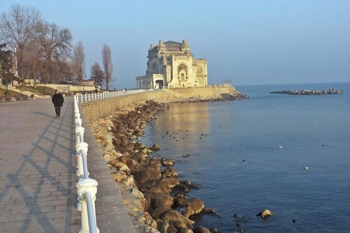 una persona che cammina lungo un marciapiede accanto a uno specchio d'acqua