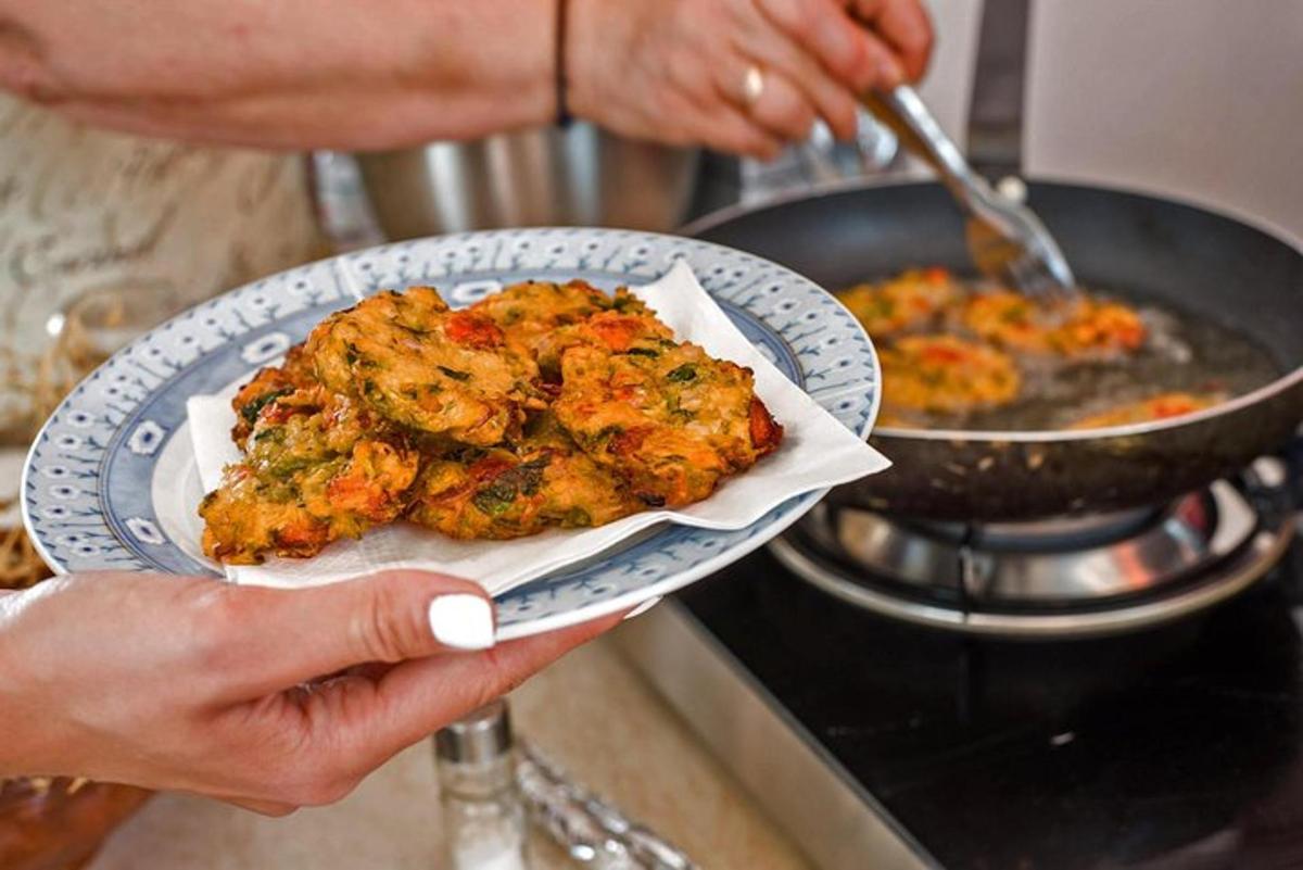 una persona que sostiene un plato de comida en una estufa