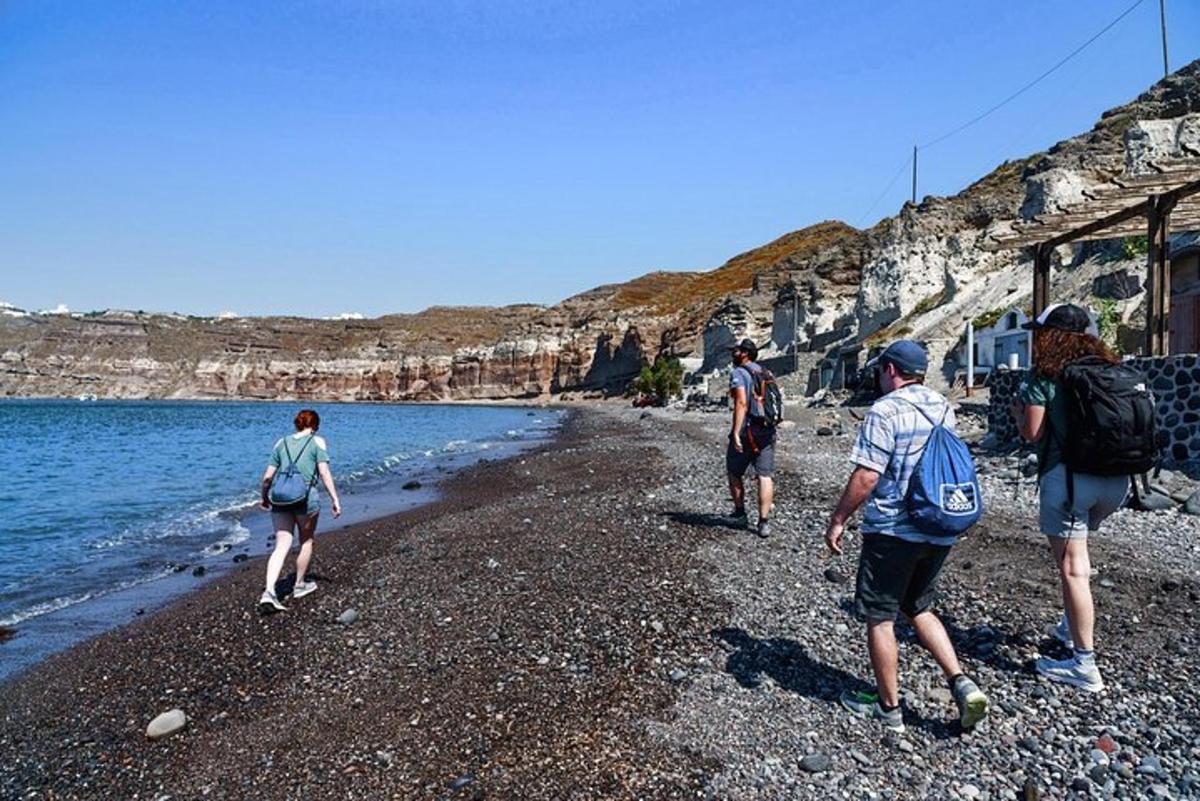 grupa ljudi hoda po stjenovitoj plaži