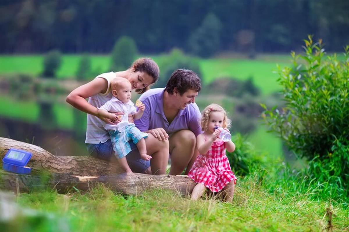uma família sentada em um tronco com duas meninas