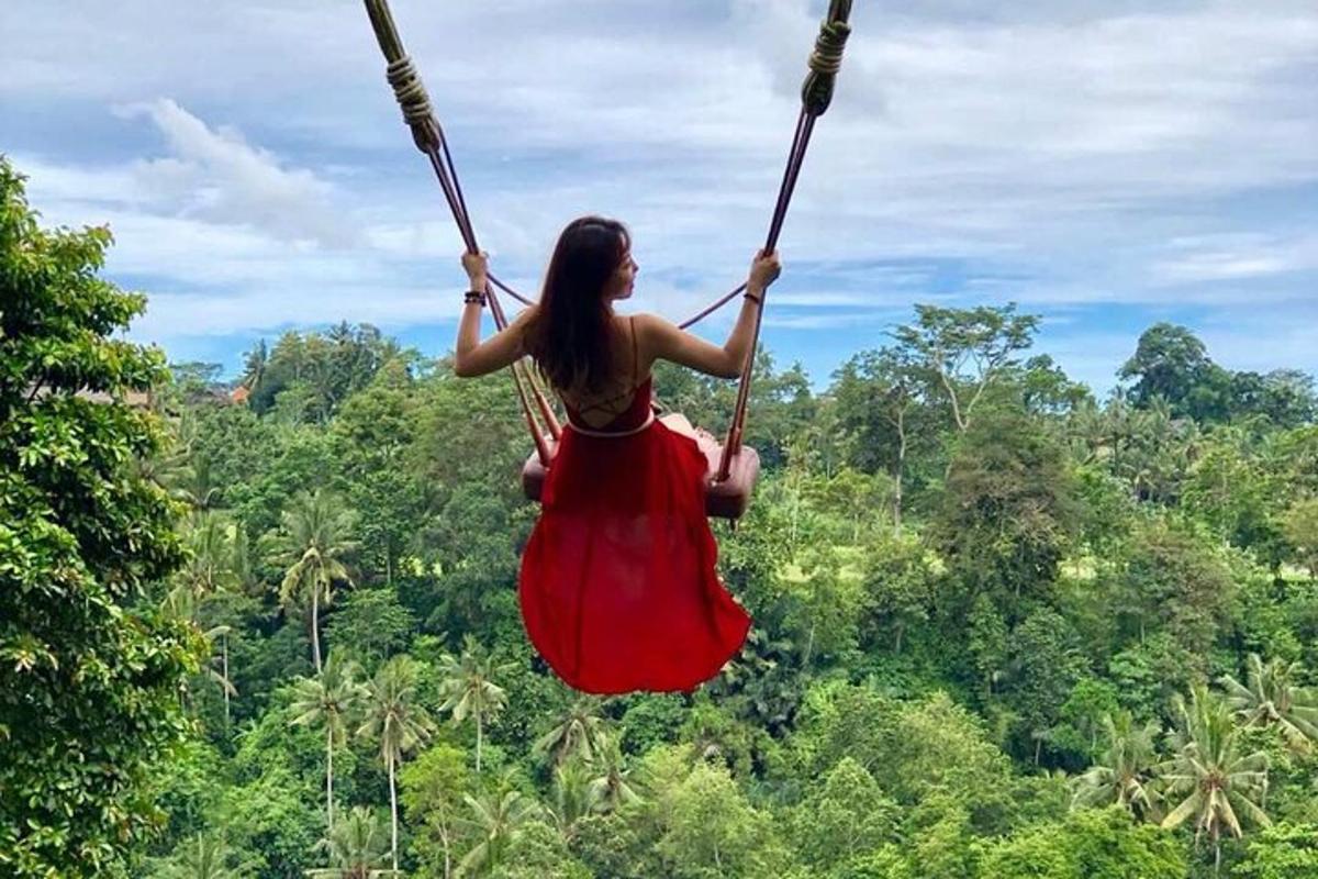isang babaeng nakasuot ng pulang damit na naka-swing sa isang swing