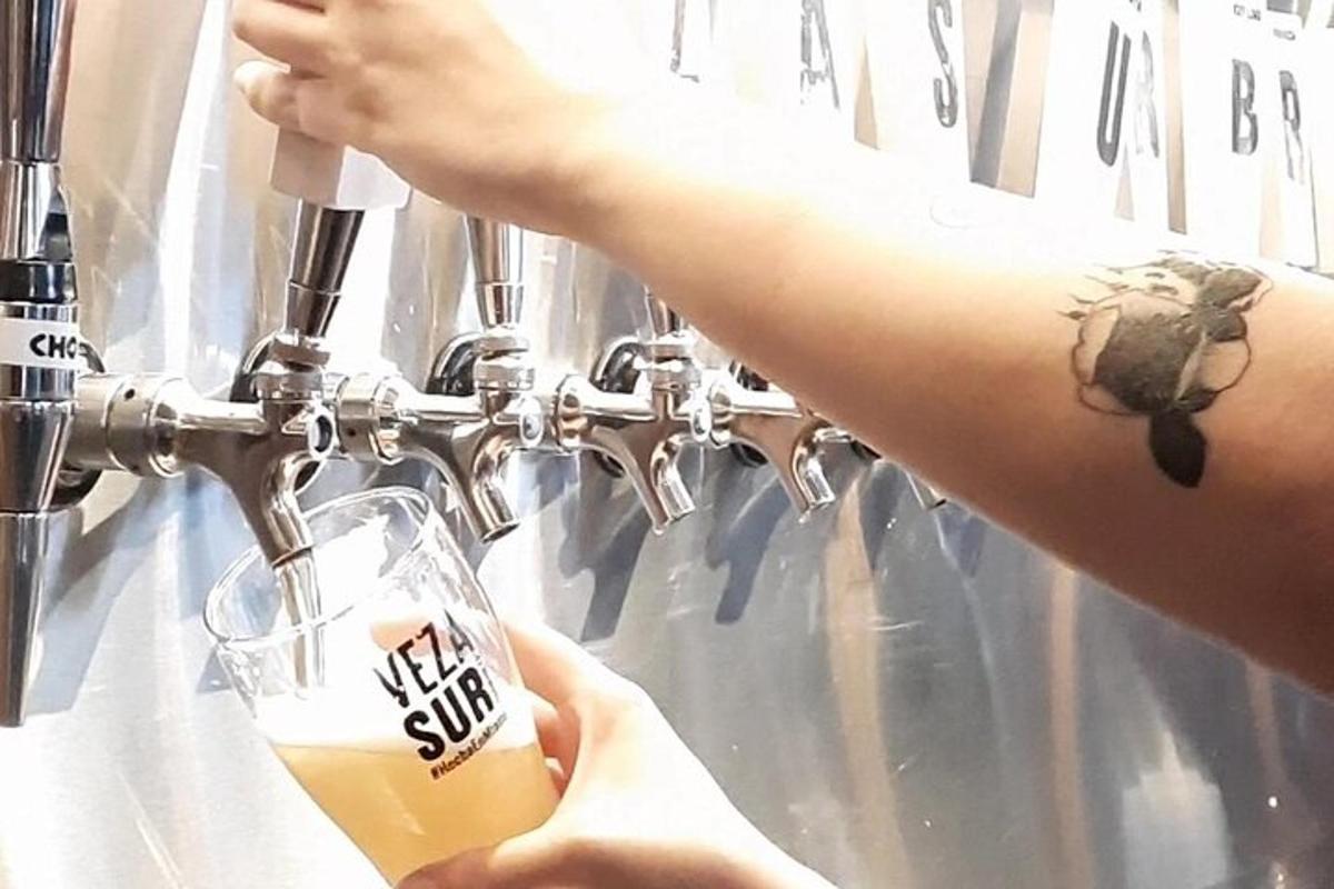 a person pouring a glass of beer in a brewery